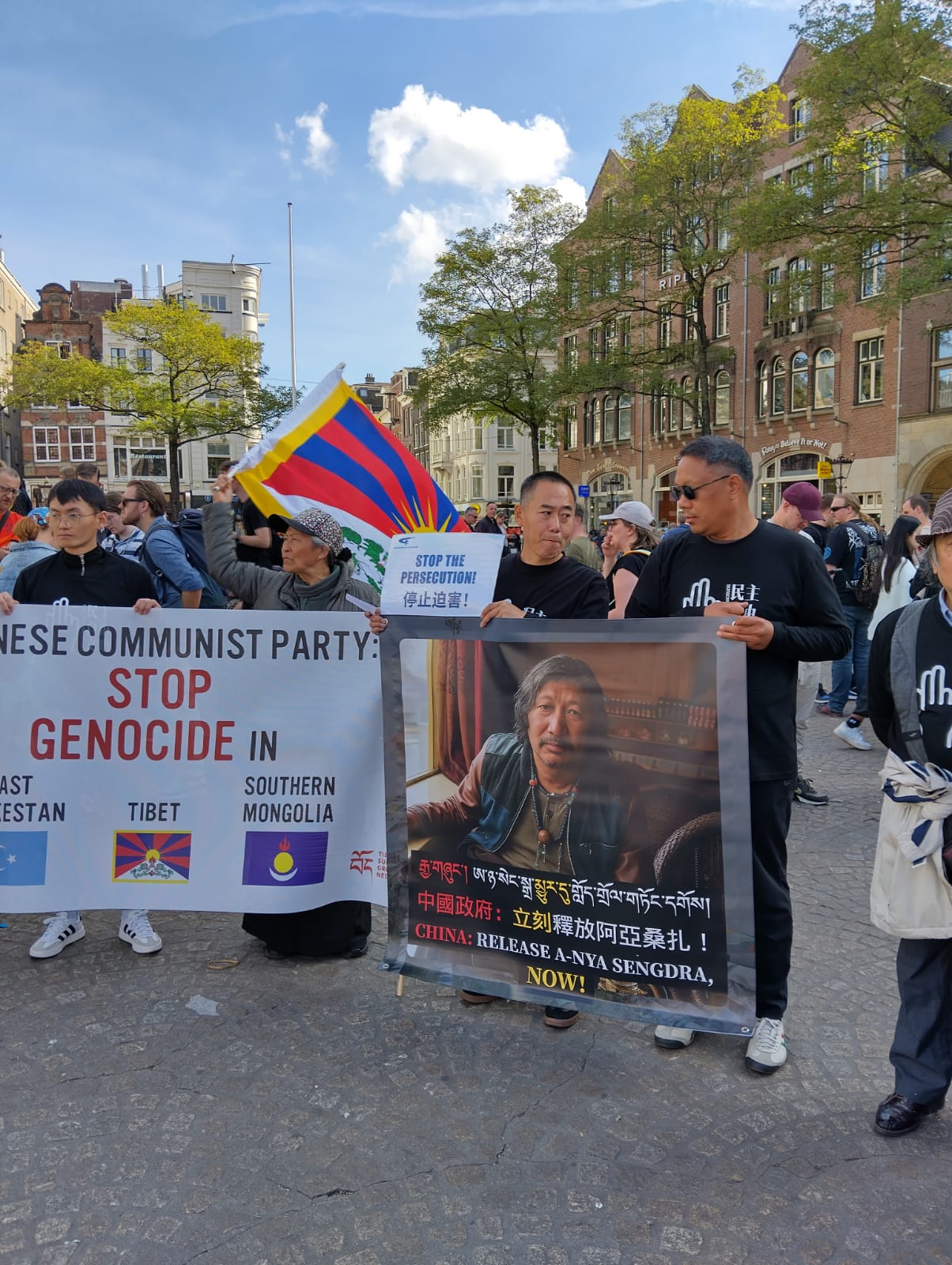 Demonstranten met protestborden tegen genocide in Tibet en andere regio's