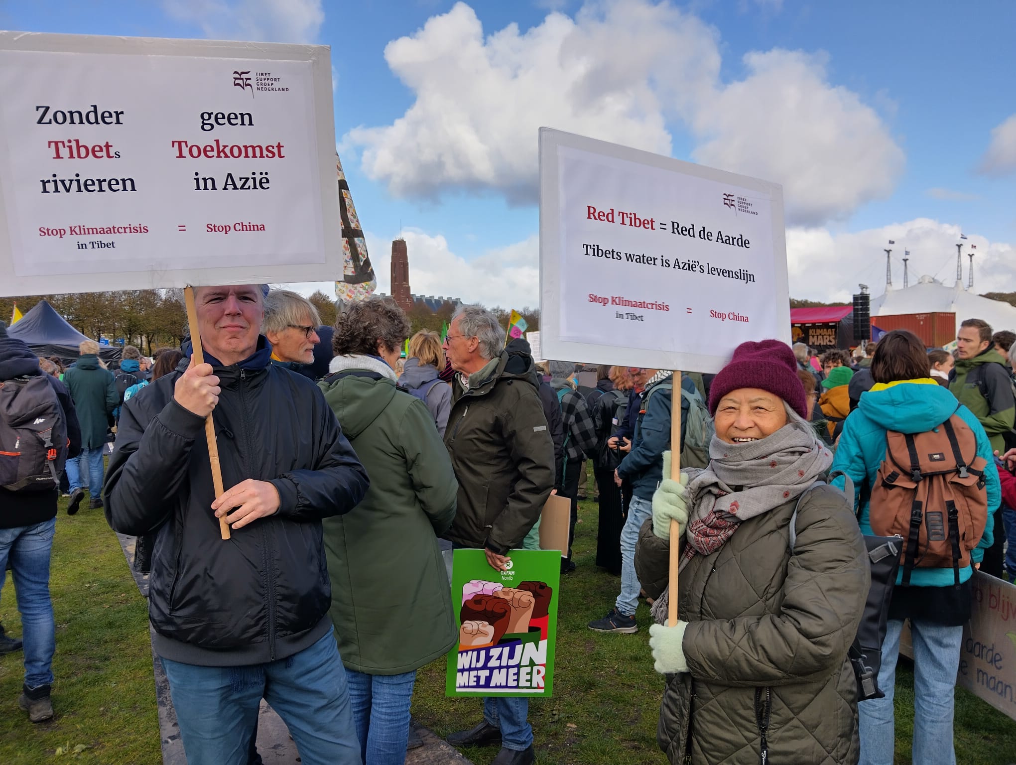 Demonstranten met Tibetaanse vlaggen en klimaatborden