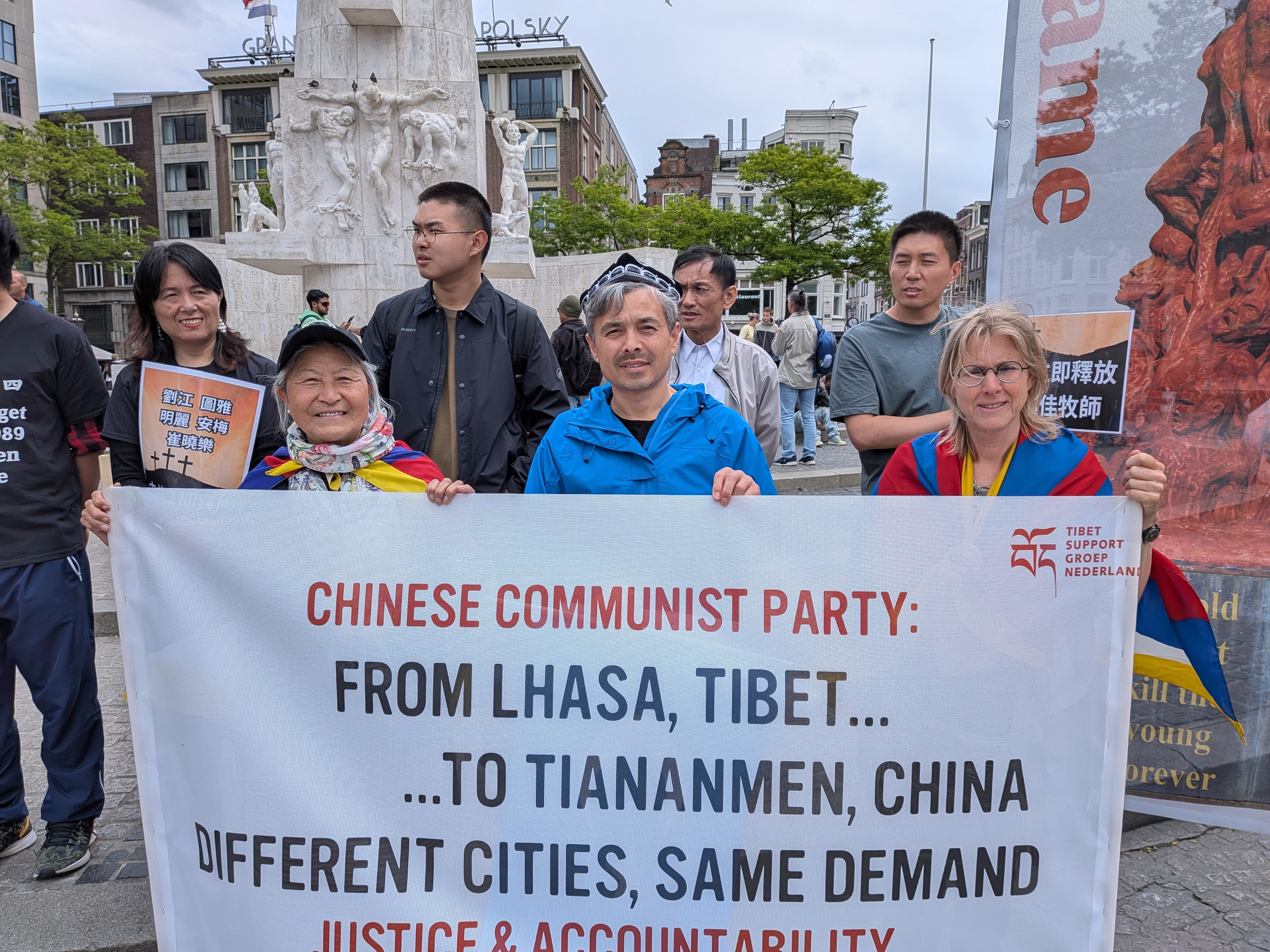 Deelnemers met het spandoek van de Tibet Support Groep Nederland op de Dam in Amsterdam, 6 juni 2026